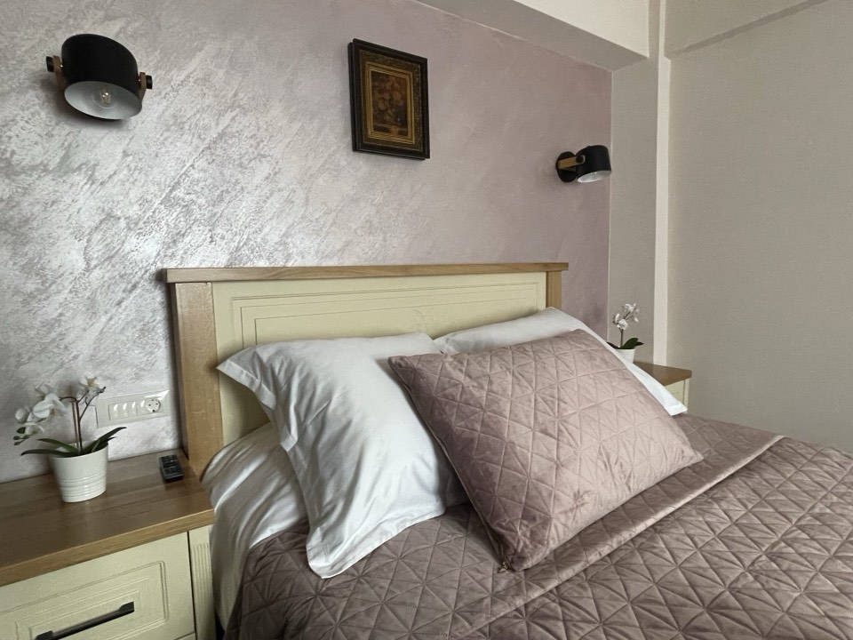 Dormitor luminos cu pat matrimonial și mobilier crem